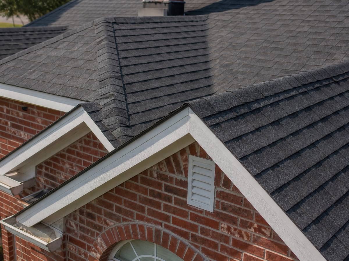 Close view of the shingle field at a gable rake, the starter course and edge fixing visible along the edge.